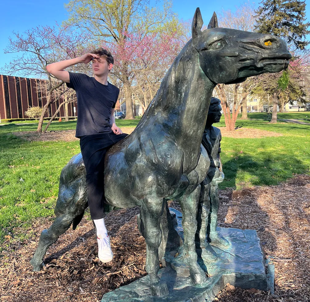 A very cool guy sitting on a horse statue